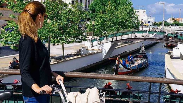 Moliceiro boat cruising along a colorful canal in Aveiro during a private tour from Porto