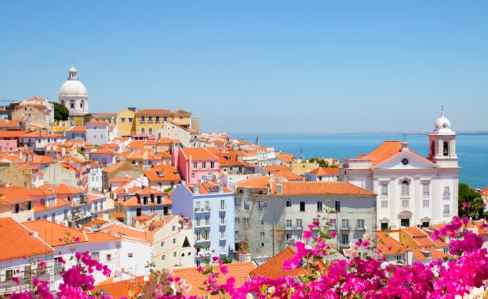 Old Lisbon cityscape with historic tram, tiled buildings, and cobbled streets in the Alfama district